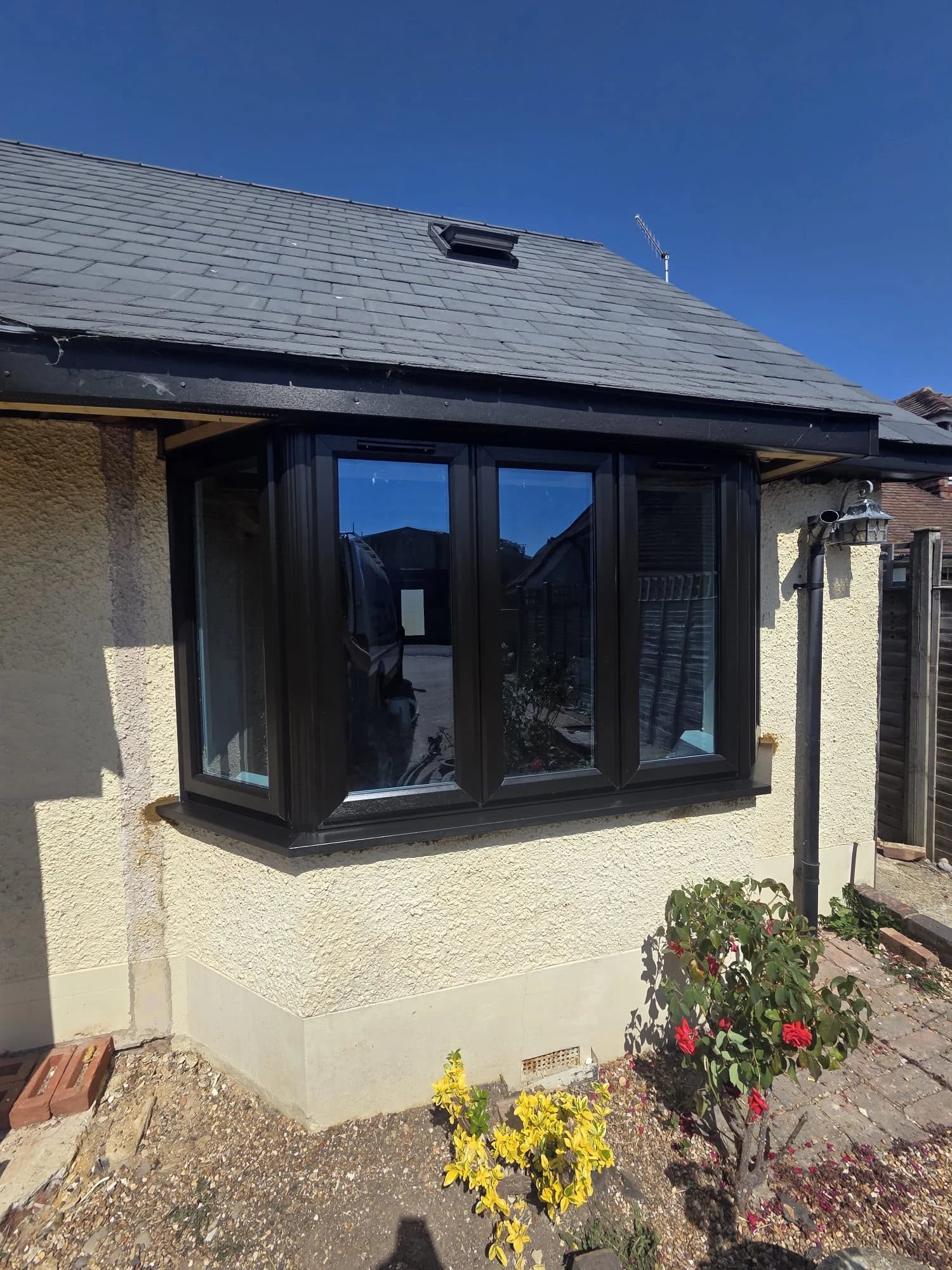 Black bay window on a cream-rendered bungalow — by A1 Window Construction Ltd