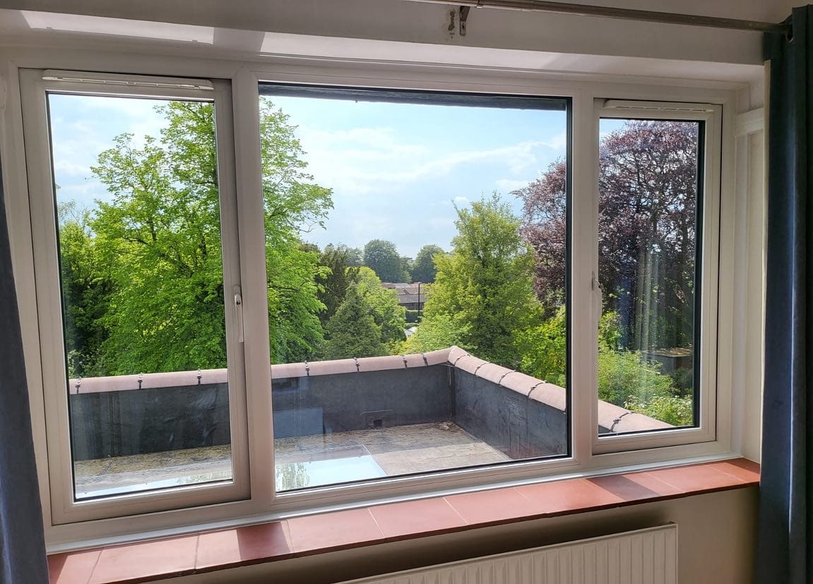 White UPVC casement windows with summer garden view — Surrey, fitted by A1 Window Construction Ltd