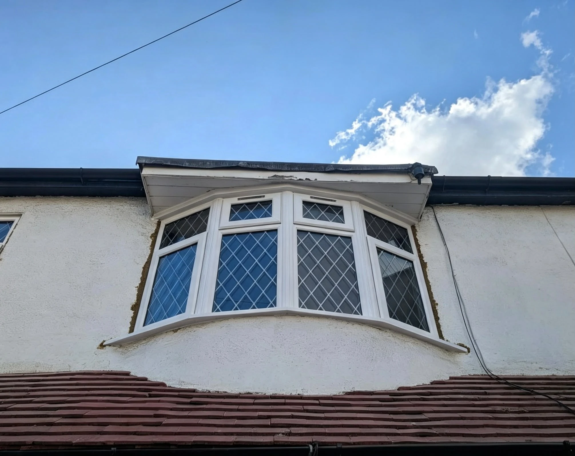White diamond-leaded curved first-floor bay window — by A1 Window Construction Ltd